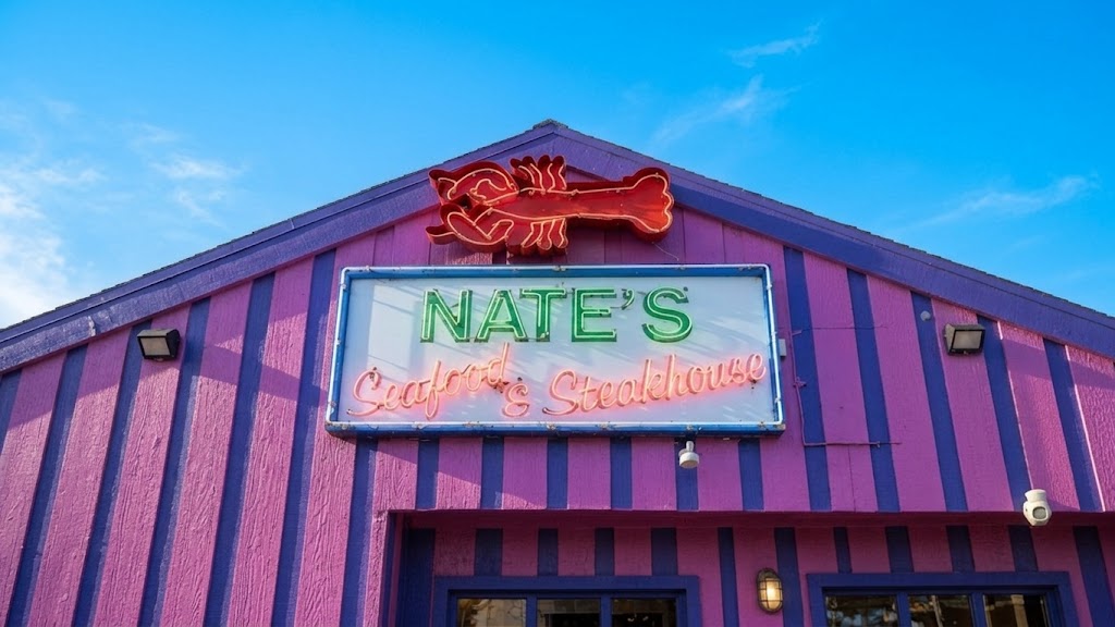 Nate's Seafood & Steakhouse neon sign glowing at dusk
