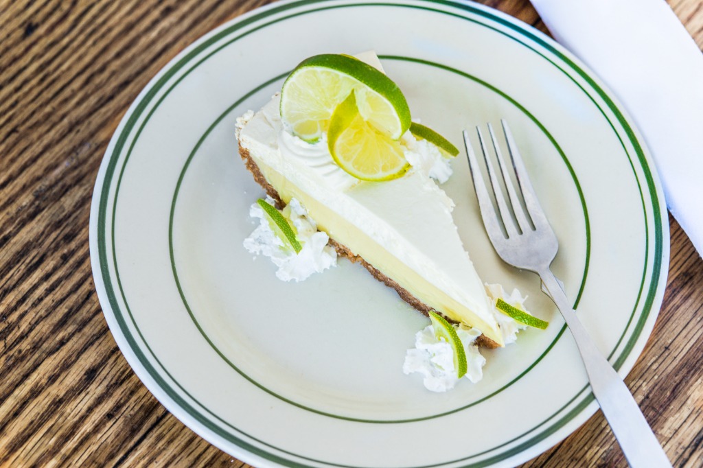 Slice of homemade Key Lime Pie with lime garnishes