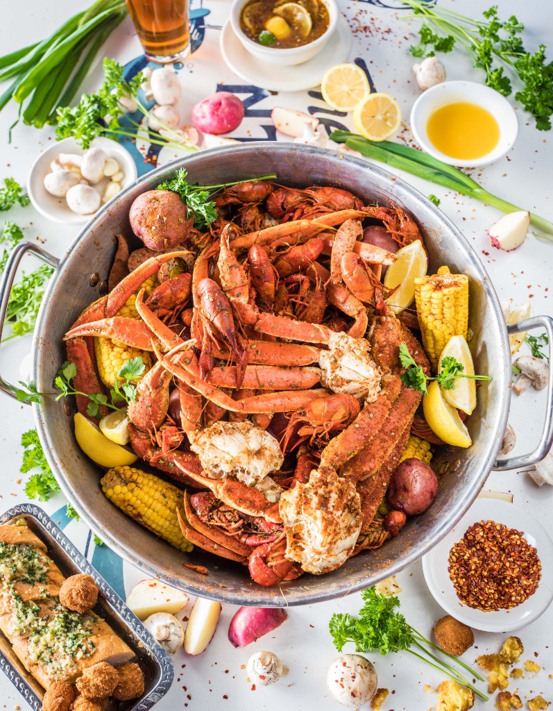 Seafood boil feast with crab legs, crawfish, corn, and garlic bread